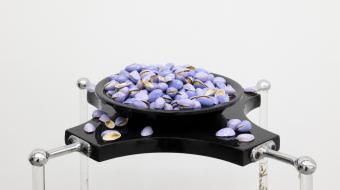 Samuel Nicolle, Garden Party #1 : Coctel D’ambiente - Las uñas de Nínive en la sombra de las Jacarandas, 2021 (détail). Bois laqué, fer, acrylique, résine et tapis d’herbe. Différents types de riz, résine, ressort en laiton. Pistaches, vernis à ongles, récipient en plastique, traces possibles de perturbateurs endocriniens. 100 x 30 x 30 cm. Courtesy de l’artiste. Photo : White Balance