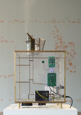 Francisco Tropa,  Fumeux fume, 2018. Eléments en laiton, plexiglas, machine à fumer, enfumoir, 82 x 50 x 50 cm. Production Le Grand Café - centre d'art contemporain, vue de l'exposition Le Grand Café, la Moustache cachée dans la barbe, 2018. Courtesy Galerie Jocelyn Wolff, Paris. Photographie Marc Domage.